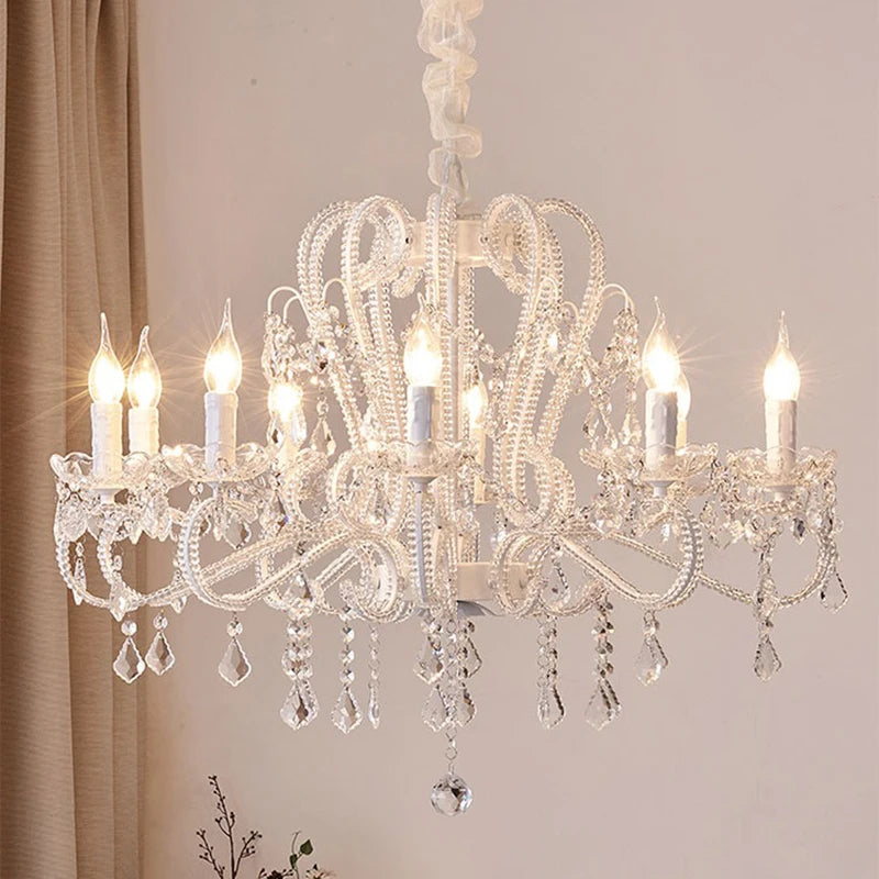 Close-up of a white candelabra chandelier with clear crystal droplets.