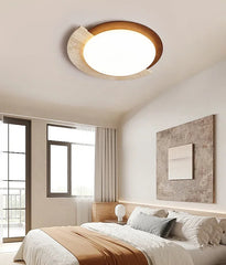Modern bedroom with a ceiling light fixture, bed, and window.