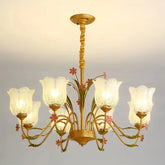 Gold chandelier with floral accents and frosted glass shades, hanging from a ceiling.