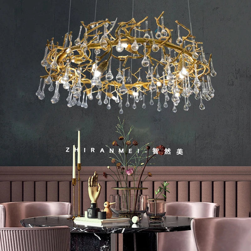 Luxury chandelier with gold branches and crystal droplets in a dining room setting.