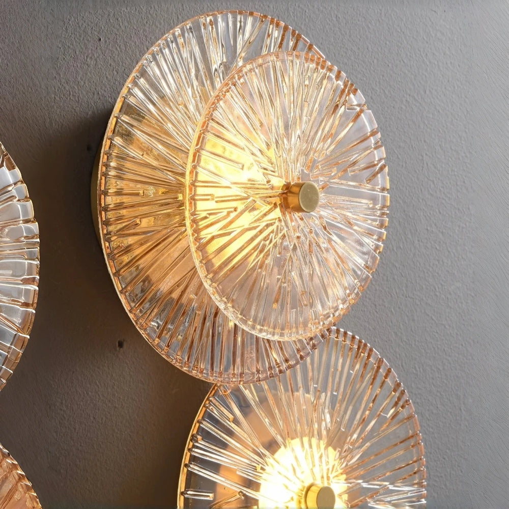 Decorative wall lights with a fan-like design on a gray wall.