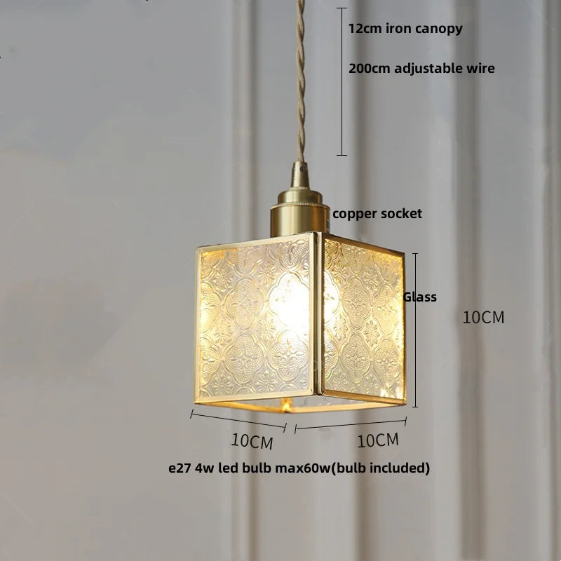 Gold pendant light with measurements on a plain background