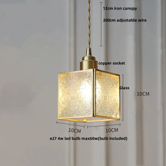 Gold pendant light with measurements on a plain background
