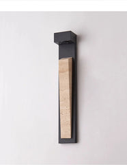 Close-up of a modern black wall sconce featuring a textured natural stone inlay.