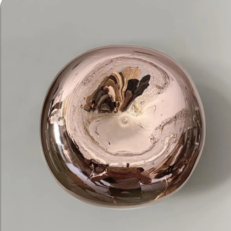 Copper pot with a reflective surface on a light gray background