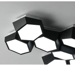 Modern ceiling light fixture with geometric design on a gray ceiling.
