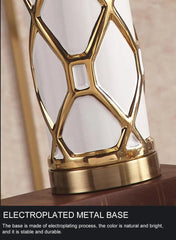 Decorative lamp with gold electroplated metal base on a neutral background