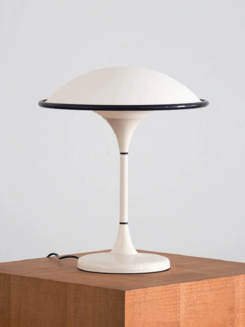 Modern table lamp with a white base and shade on a wooden surface.