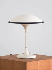 Modern table lamp with a white base and shade on a wooden surface.