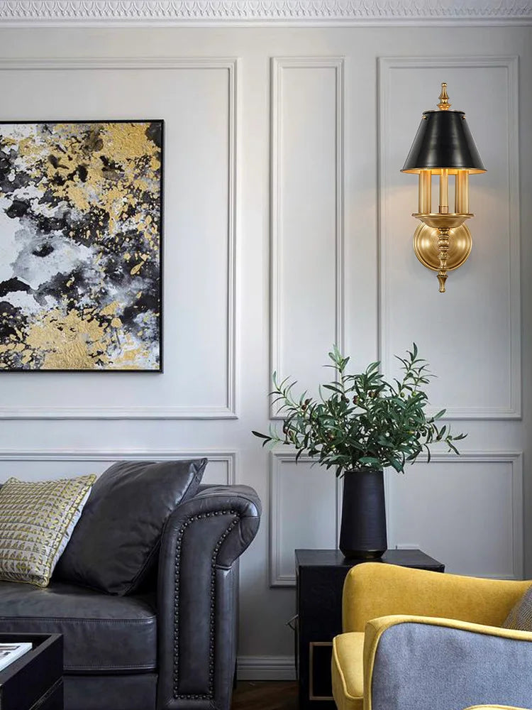 Living room with gray sofa, yellow chair, abstract art, and wall sconce.