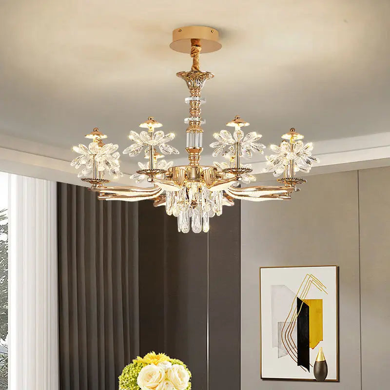 An angled view of a gold chandelier with crystal floral elements, showcasing its multi-tiered structure and polished finish.