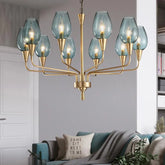 Gold chandelier with blue glass shades hanging in a living room above a sofa.