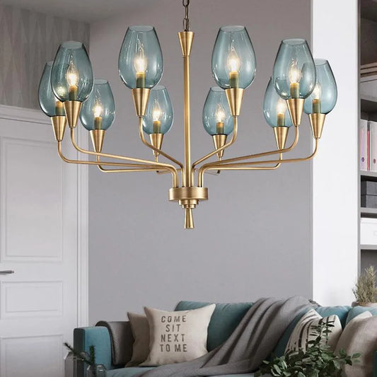 Gold chandelier with blue glass shades hanging in a living room above a sofa.