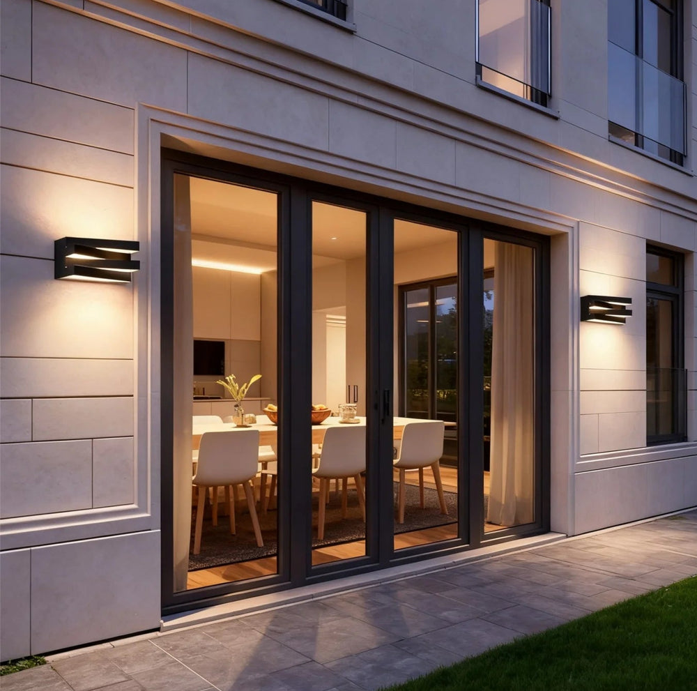 Modern house exterior with large glass doors leading to a dining area.