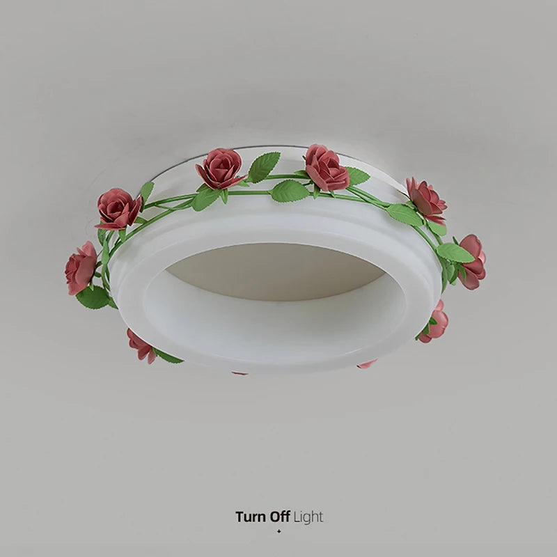 A downward view of a white semi-flush ceiling light adorned with a floral rose vine, shown with the light turned off.