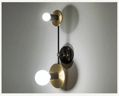 Modern wall lamp with gold and black design on a gray background