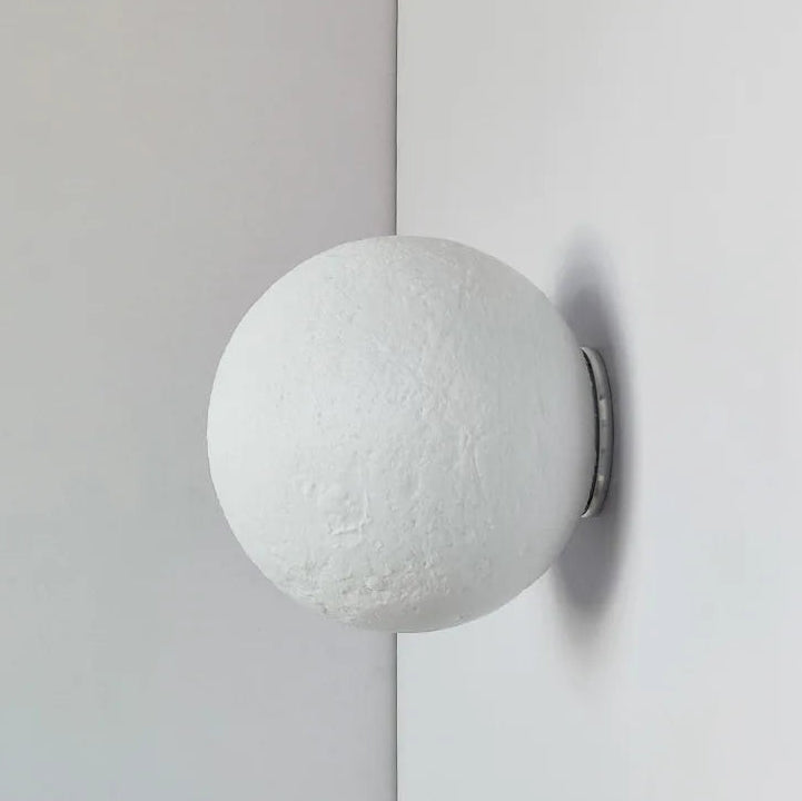 Round white wall light fixture on a gray background