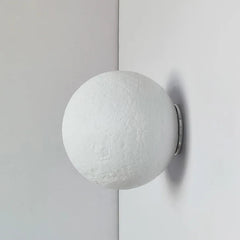 Round white wall light fixture on a gray background