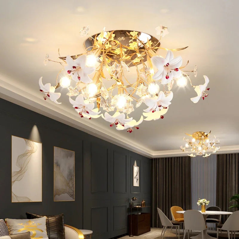 Gold floral chandelier with crystal accents and white petals in a dining room setting