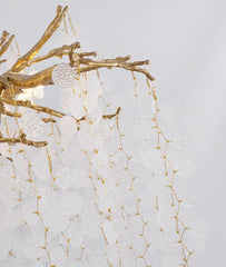 Decorative wall light fixture with gold branches on a textured white background