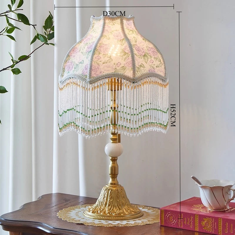 Decorative table lamp with floral lampshade on a wooden surface, with measurements indicated.