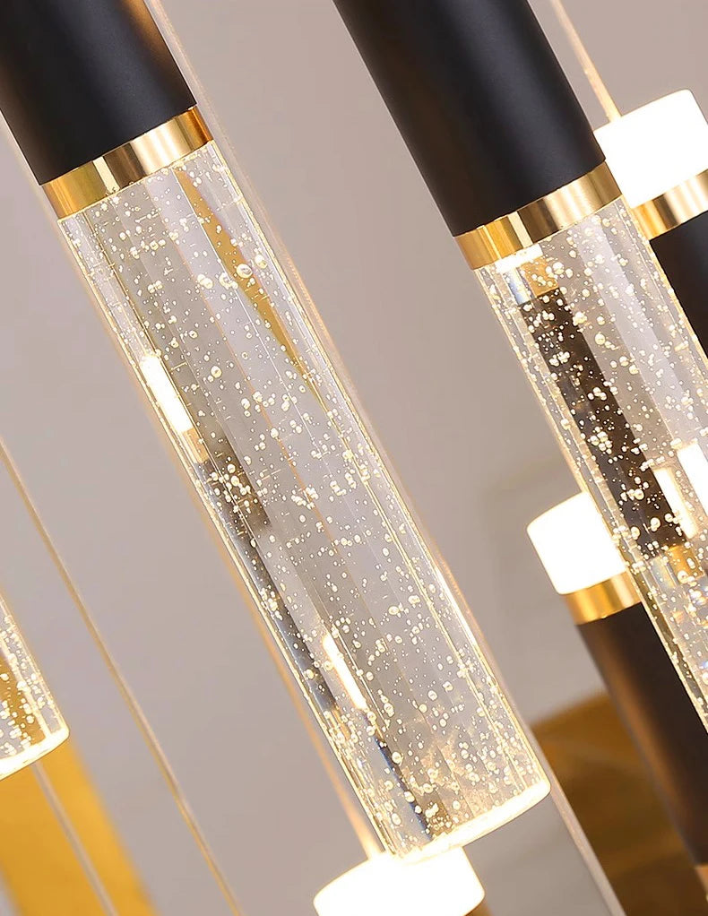 Decorative pendant lights with black, gold, and clear design on a neutral background