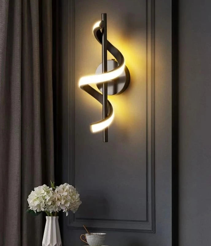 Modern wall light fixture on a dark wall with decorative elements.