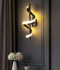 Modern wall light fixture on a dark wall with decorative elements.