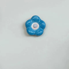 Small blue ceramic petal wall sconce mounted on a light blue wall.