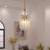 A gold cascading chandelier with crystal strands hangs from the ceiling in a well-lit room.