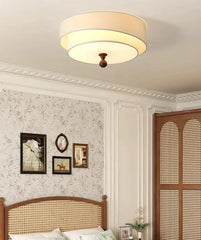 Ceiling light fixture in a bedroom with floral wallpaper and wooden headboard.