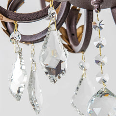 Close-up of crystal chandelier with clear glass prisms and gold accents.