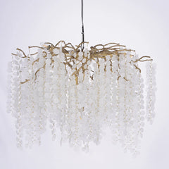 Decorative chandelier with white beads and gold accents on a light gray background