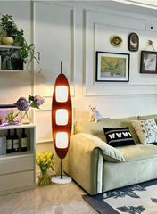 Modern living room with a unique floor lamp, sofa, and decorative elements.