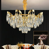 Gold cascading chandelier with teardrop crystals hanging above a living room couch