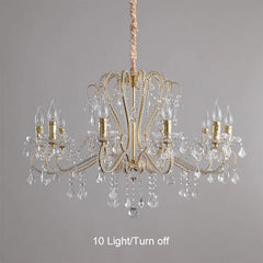 Gold chandelier with crystal accents on a gray background