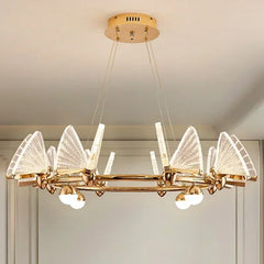 Gold chandelier with clear, translucent butterfly-shaped shades and globe lights, mounted on a ceiling.