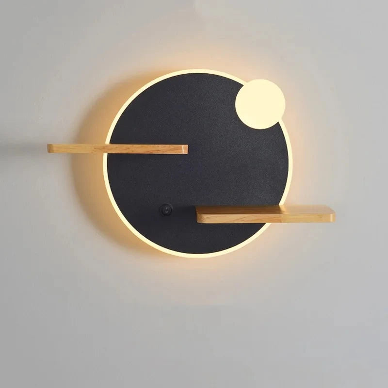 Round wall sconce with a black center, warm LED halo, a small illuminated circle accent, and two natural wood shelves, featuring a light switch.