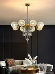 Modern chandelier hanging above a living room with a dark wall and gray sofa.