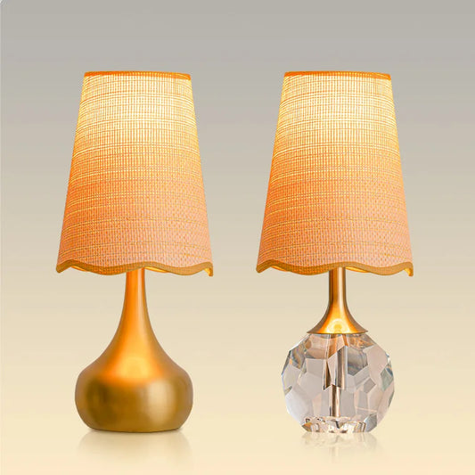 Two gold and crystal table lamps side-by-side against a neutral background.
