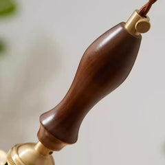 Wooden handle with gold accents on a blurred background