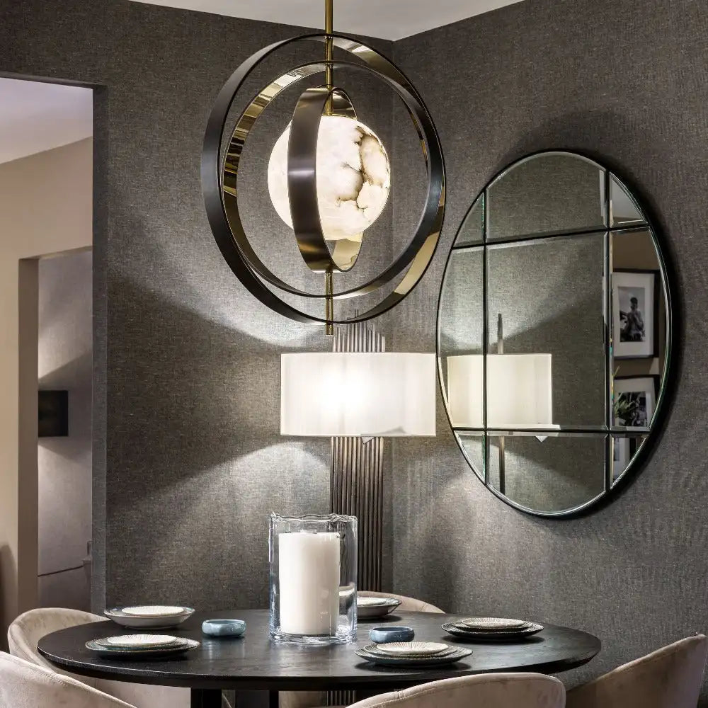 Modern interior design with round mirror, pendant light, and table setting.