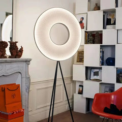 Modern floor lamp with a round, illuminated shade in a stylish room.