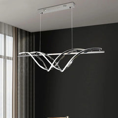 Modern pendant light hanging in a room with a dark wall and window.