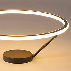 Modern table lamp with a circular glass shade and black base on a neutral background