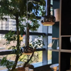 Modern pendant lights hanging above a sofa with decorative pillows in a living room setting.