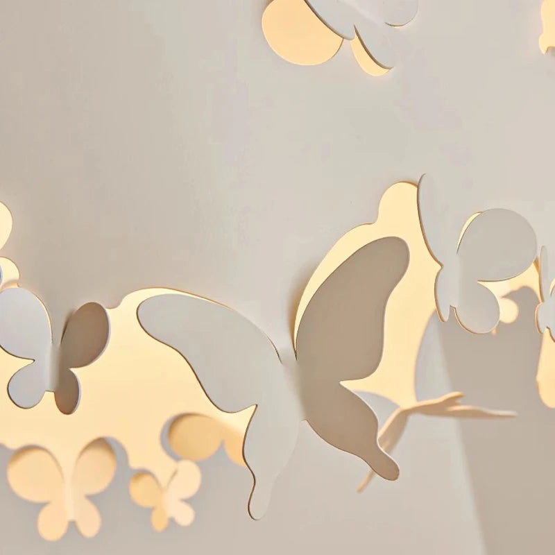 Close-up view of the cream pendant light's shade, showing the layered effect of the butterfly cutouts and the warm light emanating from within.