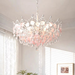 A gold-finished chandelier with multiple tiers of cascading clear crystals and round shell-like accents, hanging from a white chain.