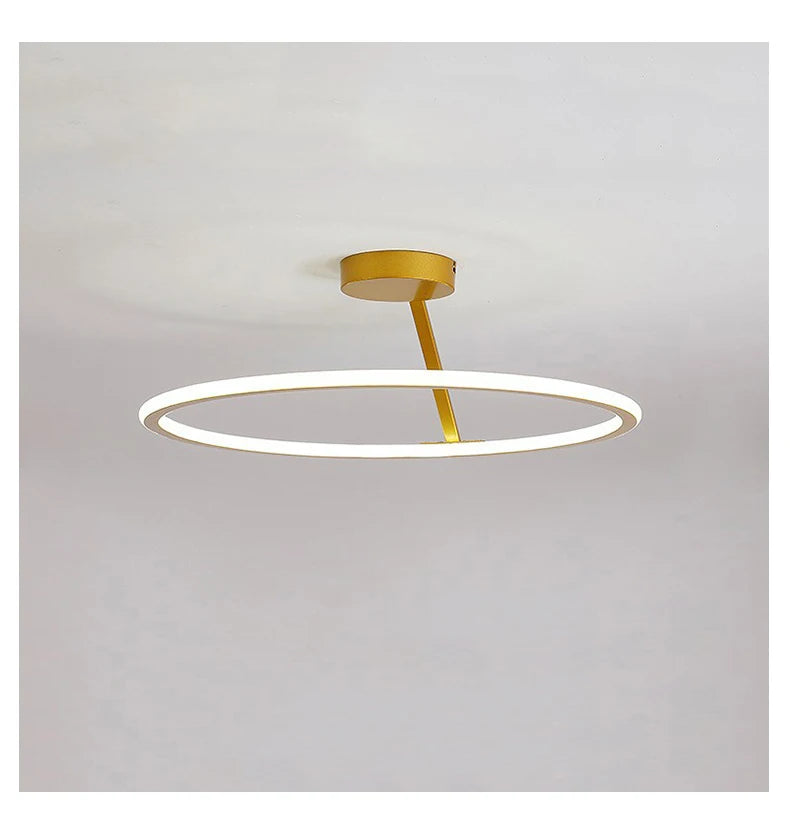 Ceiling light fixture with gold finish and white ring on a gray background