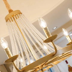 Gold chandelier with crystal accents hanging from a ceiling